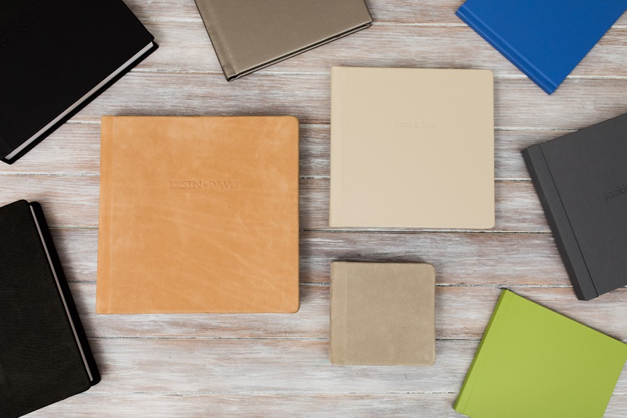 A curated arrangement of wedding albums in varied cover materials and colors