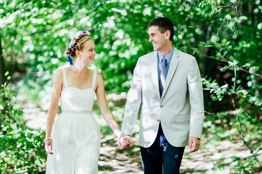 Happy bride and groom walking in woods.